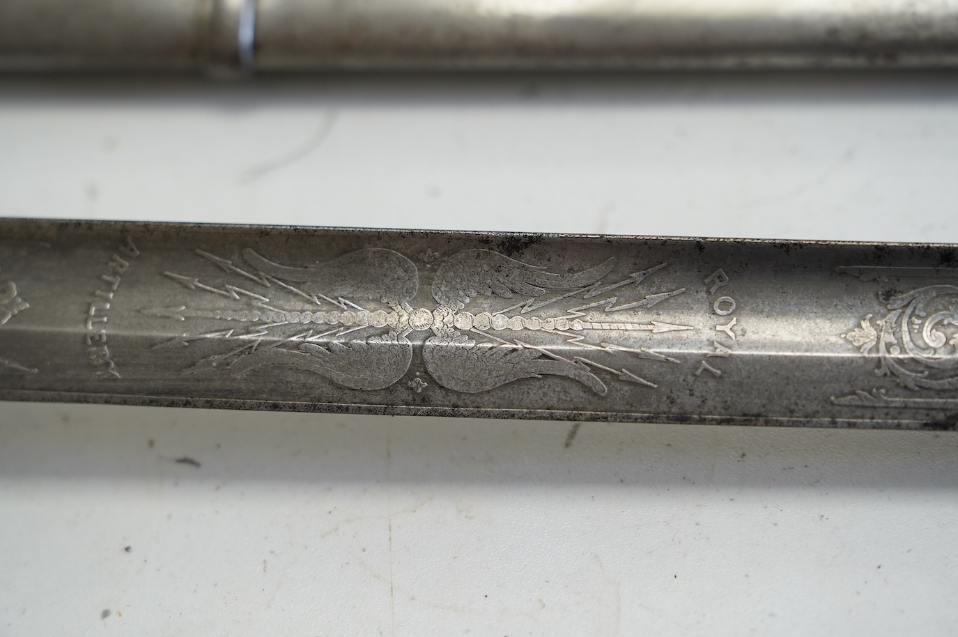 A late Victorian Royal Artillery officer’s sword by Wilkinson, No.25179, etched with regimental device, Royal Arms, owner’s crest and motto, blade 88.5cm. Condition - poor condition in a good scabbard.